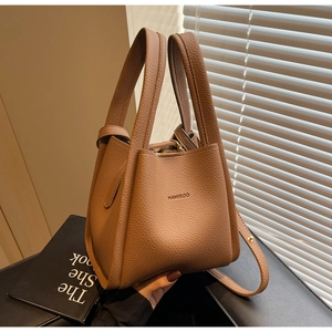 Detail of a brown litchi pattern leather bucket bag with top handle and HAMIROO logo
