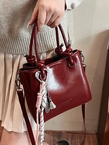 Vintage burgundy oil wax leather bucket bag with top handles and woven tassel charm