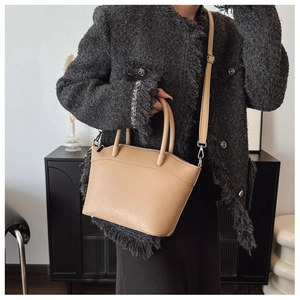 Detail of minimalist bucket bag featuring geometric quilted patterns and silver hardware