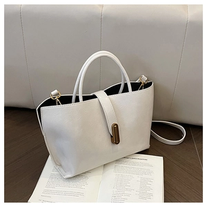 Detail of white oil wax leather bucket bag with gold oval buckle and black edge finishing
