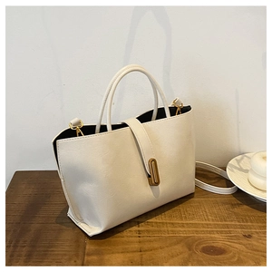 Detail of white oil wax leather bucket bag featuring gold hardware and grainy texture