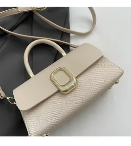 Detail of beige tote bag showing woven texture fabric and smooth leather flap with gold buckle