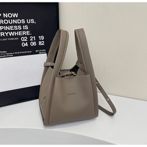 Detail of taupe litchi texture leather bucket bag with top handle and HAMIROO logo