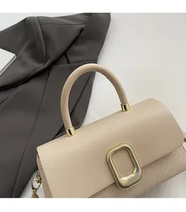 Detail of beige leather and woven texture handbag with golden square buckle detail