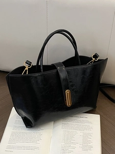 Minimalist oil wax leather bucket bag in black with gold hardware and top handle