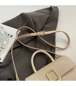 Detail of the adjustable beige leather strap and textured woven flap with gold buckle