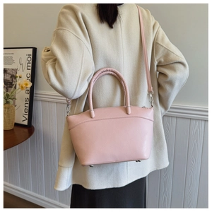 Pink bucket bag with geometric stitching shown in a minimalist indoor setting