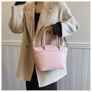 Pink PU leather bucket bag with geometric texture shown on a crossbody strap