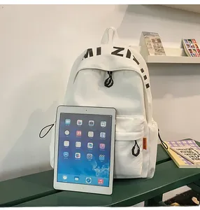 Size comparison of the white canvas backpack next to a tablet showing large capacity