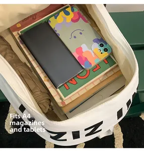 Detail of white canvas backpack showing interior capacity for A4 magazines and a tablet