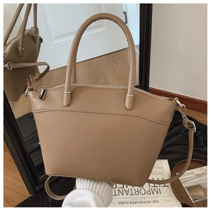 Detail of light brown faux leather bucket bag with geometric diamond embossing and dual handles