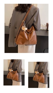 Vista detallada del bolso tote de cuero PU marrón vintage con elegante colgante de metal