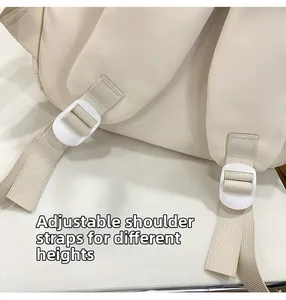 Detail of adjustable cream backpack straps with durable white plastic buckles and webbing