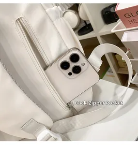 Close-up of the anti-theft back zipper pocket on a white minimalist school backpack