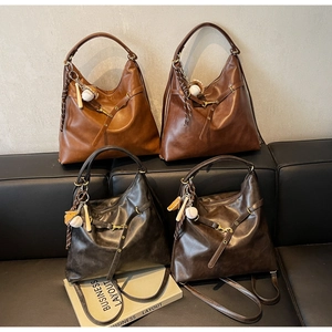 Detalle de bolsos hobo retro grandes en cuatro colores clásicos con dijes creativos