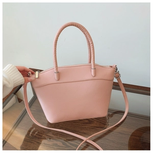Detail of pink bucket bag with geometric embossed texture and sturdy round handles