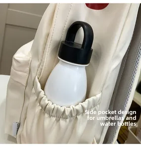Detail of the side elastic pocket on the beige backpack holding a white water bottle