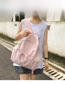 Detailed close-up of pink ballet-style backpack with bow tie and side zipper pocket
