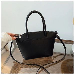 Detail view of black textured PU bucket bag with geometric embossed pattern and silver hardware