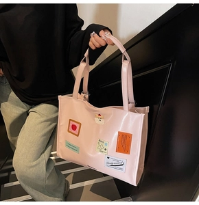 Detail der rosa Totebag aus Kunstleder mit süßen Stickereien und Teddybären-Anhänger