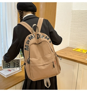 Brown casual backpack with MRMIZIZH lettering shown in a stylish lifestyle setting