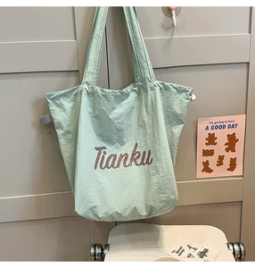 Detail view of the mint green nylon tote bag featuring Tianku letter print design