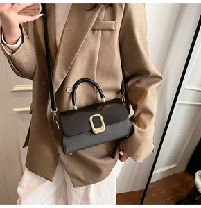Detail of black crossbody bag with smooth leather and textured woven contrast design
