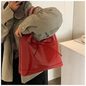 Detail of red wax leather tote bag with glossy finish and stylish bow decoration