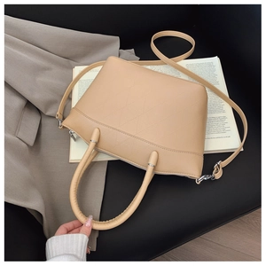 Detailed close-up of geometric quilted patterns and silver hardware on a leather bucket bag