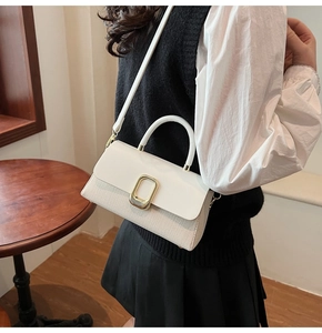 Detailed view of the woven fabric and leather patchwork on the white crossbody bag