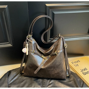 Detalle del bolso tote marrón oscuro con textura mate retro y colgante de béisbol único