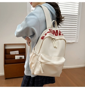 Detail of off-white nylon backpack with red CHINA print and woven zipper pulls
