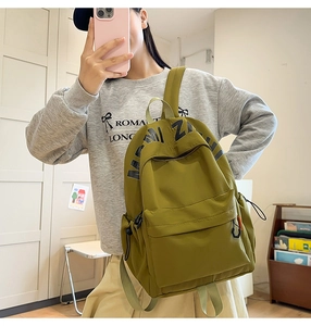 Detail view of the olive green nylon backpack showing durable fabric and black MI ZA logo