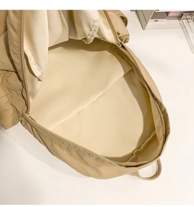 Detailed interior view of the spacious main compartment of the beige school backpack