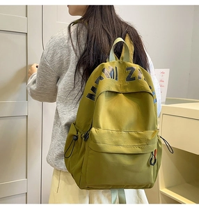 Detailed view of an olive green canvas backpack with MIZI lettering on top cover