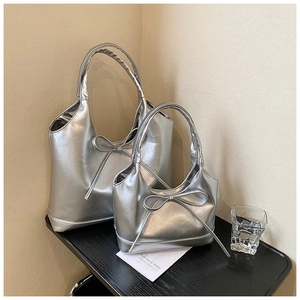 Detail of silver oil wax leather tote and shoulder bag with elegant bow accents