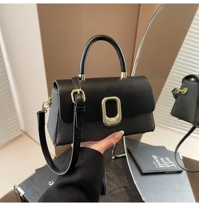 Detail of two-tone square handbag with grey woven fabric and gold metal buckle closure