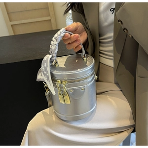 Detail of silver cylinder handbag with heart print scarf wrapped on the handle