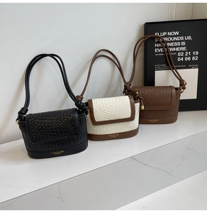 Détail des coloris pour sacs bandoulière à texture tissée sur une surface en marbre