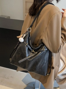 Bolso tote negro clásico en cuero suave con detalles dorados y amuleto para mujeres