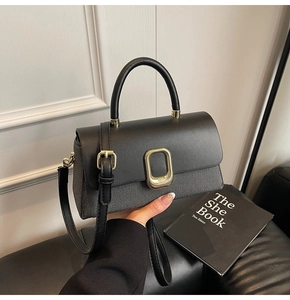 Detail showing high-quality black leather and woven fabric texture with gold clasp