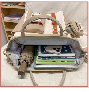 Détail de l'intérieur du sac à dos en toile montrant des livres et une tablette