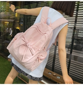 Detail of light pink ballet-style backpack with ribbon bow and side storage pocket