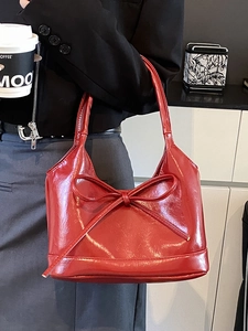 Glossy red faux leather underarm tote bag with a large decorative bow for women