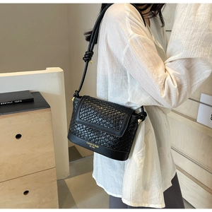 Gros plan du sac seau noir à texture tressée avec bandoulière à nœud personnalisée