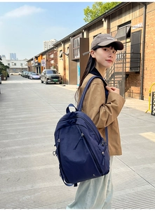 Detail of navy blue leisure backpack with front zipper pockets and wide shoulder straps