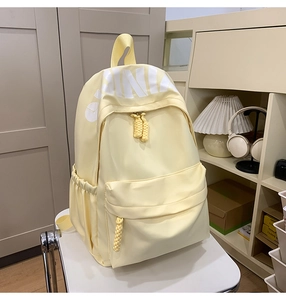Detail of cream backpack showing the large CHINA print and woven cord zipper pullers