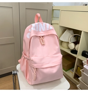 Close-up of pink backpack showing white CHINA lettering and durable nylon fabric detail