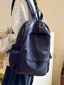 Navy blue large capacity canvas backpack with minimalist collegiate style and side straps
