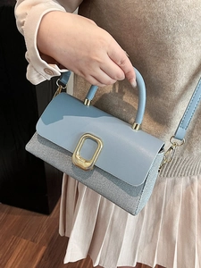 Elegant light blue square handbag with woven texture and gold buckle shown on model